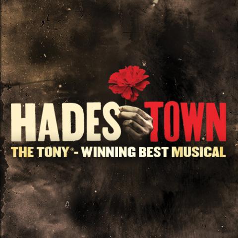 Hadestown wording with a hand holding a rose in between the letters hades and town.