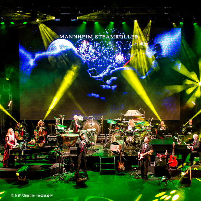 Mannheim Steamroller band on stage with a green lights alluminating the stage