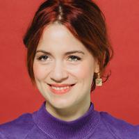 Wetterlund in a purple sweater in front of a red backdrop