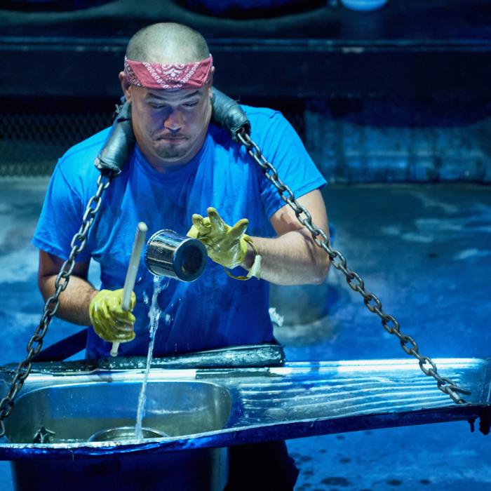 Musician playing a sink as a drum